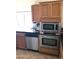 Modern kitchen featuring stainless steel appliances, oak cabinets, and a sleek black countertop at 1502 E Estrid Ave, Phoenix, AZ 85022