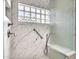 Bright bathroom featuring marble shower with glass block window and convenient grab bar at 15377 W Catalina Ct, Goodyear, AZ 85395