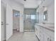 Modern bathroom with a frameless glass shower, white cabinets, and gray tile flooring at 15377 W Catalina Ct, Goodyear, AZ 85395