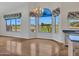 Bright dining area with large windows overlooking golf course, chandelier, and tile flooring at 15377 W Catalina Ct, Goodyear, AZ 85395