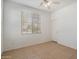 Bright bedroom with a ceiling fan, neutral walls, a large window for natural light, and a white door at 15910 W Fillmore St, Goodyear, AZ 85338