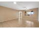 Bright, neutral living room showcasing tile floors, ceiling fan and ample space at 15910 W Fillmore St, Goodyear, AZ 85338