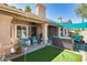 Covered patio with seating area and putting green with a stucco wall at 16250 S 13Th St, Phoenix, AZ 85048