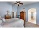 Bedroom featuring wood furniture, arched entryway, and exercise bike at 16250 S 13Th St, Phoenix, AZ 85048