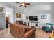 Comfortable living room with vaulted ceiling, brown couches, and a ceiling fan at 16250 S 13Th St, Phoenix, AZ 85048