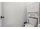 Bathroom featuring a white toilet and a white cabinet over it with two rolls of toilet paper on an open shelf at 16559 W Lincoln St, Goodyear, AZ 85338