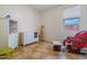 Bedroom featuring a rocking chair, dresser, and a giraffe toy on light colored tile at 16559 W Lincoln St, Goodyear, AZ 85338