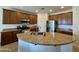 A kitchen features granite countertops and an island sink with wood cabinets at 16559 W Lincoln St, Goodyear, AZ 85338