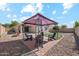 Spacious backyard with covered seating area, fire pit, green turf, and desert landscaping at 1718 E Harwell Rd, Phoenix, AZ 85042