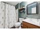 Well-lit bathroom with a shower-tub, modern vanity, dark green walls, and decorative shelves at 1718 E Harwell Rd, Phoenix, AZ 85042