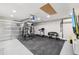 Home gym featuring a weight rack, treadmill, flat screen TV, and durable flooring in the large garage at 1718 E Harwell Rd, Phoenix, AZ 85042