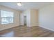 Neutral bedroom featuring wood-look floors, base trim, and a bright window at 17441 N Del Webb Blvd, Sun City, AZ 85373