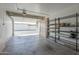 Spacious garage with storage shelves and a wide garage door to exterior at 17441 N Del Webb Blvd, Sun City, AZ 85373