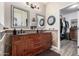 Bathroom with double vanity, decorative mirrors, tiled accent wall, and access to walk-in closet at 17664 W Marshall Ln, Surprise, AZ 85388