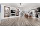 Open-concept living space with wood flooring, a fireplace, built-ins, and seamless flow into the kitchen at 17664 W Marshall Ln, Surprise, AZ 85388
