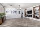 Living room with a modern fireplace, built-in shelving, wood floors, and bright, neutral decor at 17664 W Marshall Ln, Surprise, AZ 85388