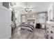 Well-lit main bedroom featuring hardwood flooring, a ceiling fan, and a decorative headboard at 17664 W Marshall Ln, Surprise, AZ 85388