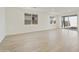 Spacious and bright living room featuring light wood-style floors, white walls, and sliding doors to the outside at 19028 W Rose Ln, Waddell, AZ 85355
