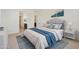 Stylishly staged primary bedroom with blue accents, carpet, and a view of the en-suite bathroom at 19028 W Rose Ln, Waddell, AZ 85355