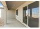 Covered patio area features a smooth concrete floor and sliding glass doors to the home's interior at 19028 W Rose Ln, Waddell, AZ 85355