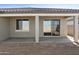 A view of the backyard patio area with concrete flooring and desert landscaping around the house at 19028 W Rose Ln, Waddell, AZ 85355