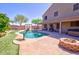 Inviting backyard featuring a sparkling pool, covered patio, built-in barbeque, and lush green grass at 2008 N Pablo Ct, Casa Grande, AZ 85122