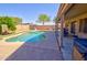 Relaxing outdoor space with a pool, covered patio, and mature tree at 2008 N Pablo Ct, Casa Grande, AZ 85122