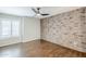 Bedroom featuring new hard floors, ceiling fan, brick wall and lots of natural light at 2025 E Campbell Ave # 143, Phoenix, AZ 85016