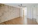 Large bedroom with brick wall, hardwood floors, ceiling fan and view of hallway at 2025 E Campbell Ave # 143, Phoenix, AZ 85016