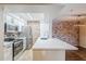 Open kitchen featuring stainless appliances, quartz countertops and a brick wall at 2025 E Campbell Ave # 143, Phoenix, AZ 85016