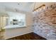 Beautiful kitchen featuring white cabinets, stainless appliances, stone countertops and a brick wall at 2025 E Campbell Ave # 143, Phoenix, AZ 85016