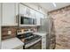 Updated kitchen featuring stainless steel appliances, white cabinets and a brick backsplash at 2025 E Campbell Ave # 143, Phoenix, AZ 85016