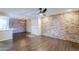 Spacious living room boasting wood floors, brick accent wall, and plenty of natural light at 2025 E Campbell Ave # 143, Phoenix, AZ 85016