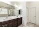 A bright bathroom with double sink vanity, large mirror, and enclosed shower at 2176 W Larissa Ln, San Tan Valley, AZ 85144