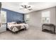 Inviting bedroom with navy blue accent wall, carpet flooring, and a ceiling fan at 2176 W Larissa Ln, San Tan Valley, AZ 85144