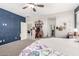 A bedroom with a patterned navy accent wall, a ceiling fan, and two entry doors at 2176 W Larissa Ln, San Tan Valley, AZ 85144