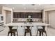 A stylish kitchen with dark cabinets, tiled backsplash, stainless appliances and large center island with seating at 2176 W Larissa Ln, San Tan Valley, AZ 85144
