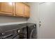 Laundry room featuring front load washer and dryer under wooden cabinets and a white door at 22432 N 52Nd Pl, Phoenix, AZ 85054