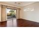 Bright living room with dark wood floors, large sliding glass doors, and modern ceiling fan at 22432 N 52Nd Pl, Phoenix, AZ 85054