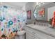 Charming bathroom featuring a floral shower curtain, marble vanity, and colorful artwork for a vibrant, inviting space at 2316 N 81St St, Scottsdale, AZ 85257