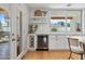 Bright kitchen area featuring a wine cooler, open shelving, and a large window offering views of the outdoor space at 2316 N 81St St, Scottsdale, AZ 85257