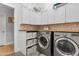 Well-organized laundry room with white cabinets, wood countertops, and modern washer and dryer units at 2316 N 81St St, Scottsdale, AZ 85257