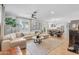 Bright and airy living room features hardwood floors, a modern sectional sofa, and an open layout to the kitchen and dining at 2316 N 81St St, Scottsdale, AZ 85257