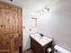 Bathroom featuring a wooden vanity, oval sink, and a rustic wooden door at 23833 N 36Th Dr, Glendale, AZ 85310