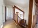 Hallway with a wooden railing leading to the staircase, open to a naturally lit living space at 23833 N 36Th Dr, Glendale, AZ 85310