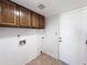 Functional laundry area with tile flooring, storage cabinets, and washer/dryer hookups at 23833 N 36Th Dr, Glendale, AZ 85310