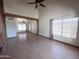 Spacious living room featuring wood floors, ceiling fan, and natural light from many windows at 23833 N 36Th Dr, Glendale, AZ 85310