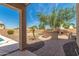 This backyard features a brick patio with a outdoor kitchen and green landscaping at 26272 N 73Rd Dr, Peoria, AZ 85383