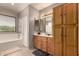 Bright bathroom with wood cabinets, bath tub, and linen storage at 26272 N 73Rd Dr, Peoria, AZ 85383