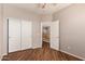 This bedroom features wood floors, a ceiling fan, and a closet with sliding doors at 26272 N 73Rd Dr, Peoria, AZ 85383